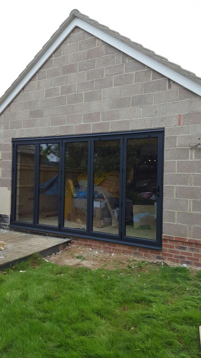 Black-framed sliding doors of a house, with a view of the interior.